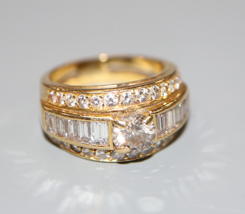 A modern yellow metal and three row diamond set dress ring, size J, gross 7 grams, set with round and baguette cut stones.
